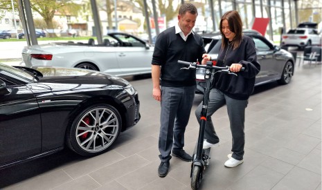 Kundin mit E-Scooter und Verkäufer